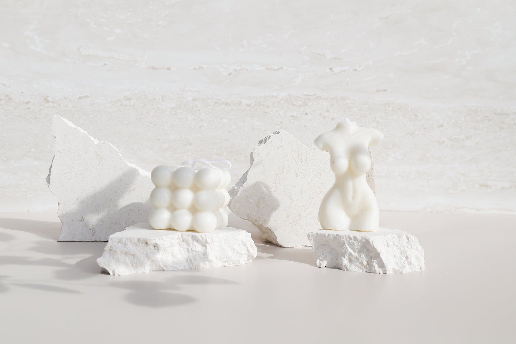 naked lady and cube candles on white limestone stone props with creamy travertine stone waterproof photography backdrop - backdrop collective australia