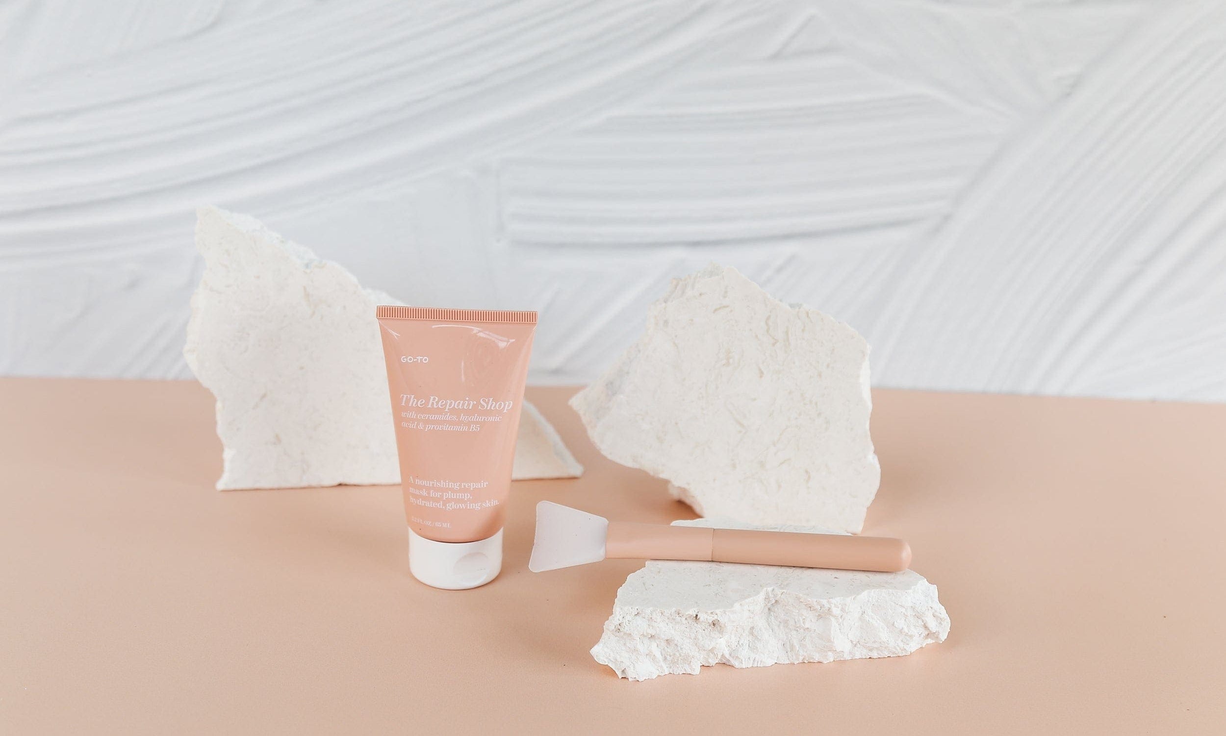 concrete and peach textured waterproof vinyl photography backdrops for product photography with travertine stone props - backdrop collective