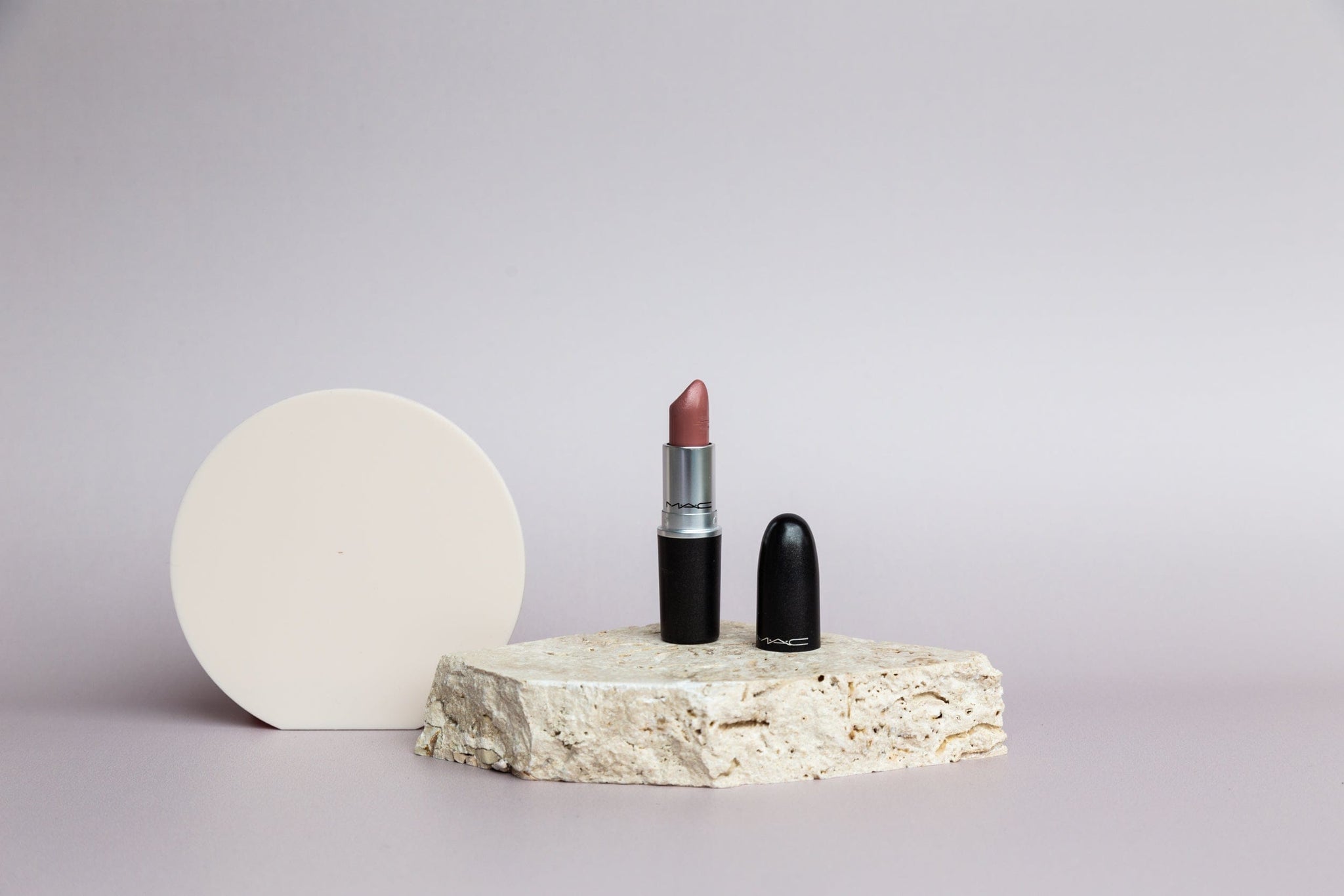 travertine stone and beige circle prop on taupe vinyl backdrop with mac lipstick - backdrop collective australia