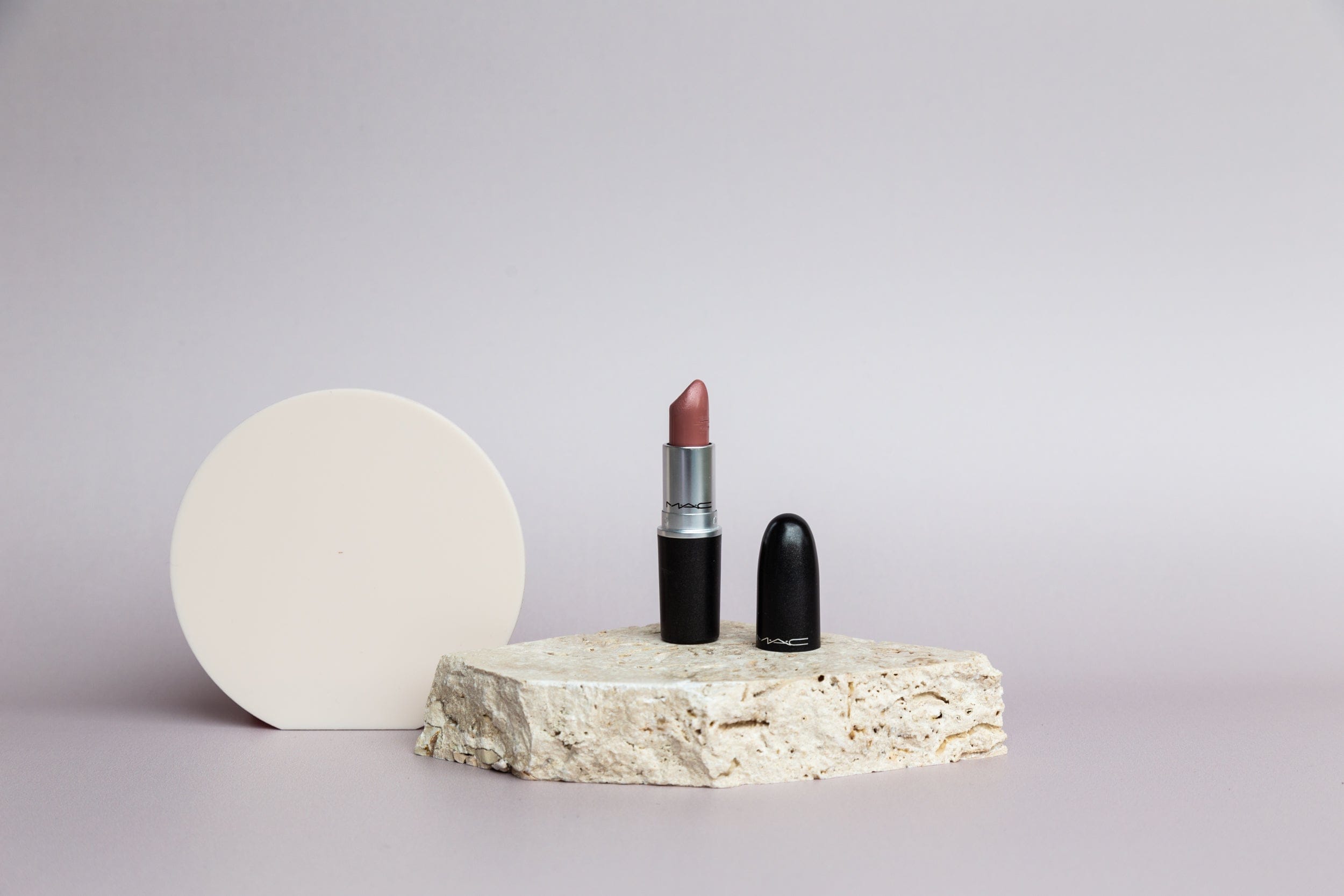 small buttercream beige acrylic circle and travertine stone photography props photographed with mac lipstick and taupe seamless vinyl photography backdrop - backdrop collective australia