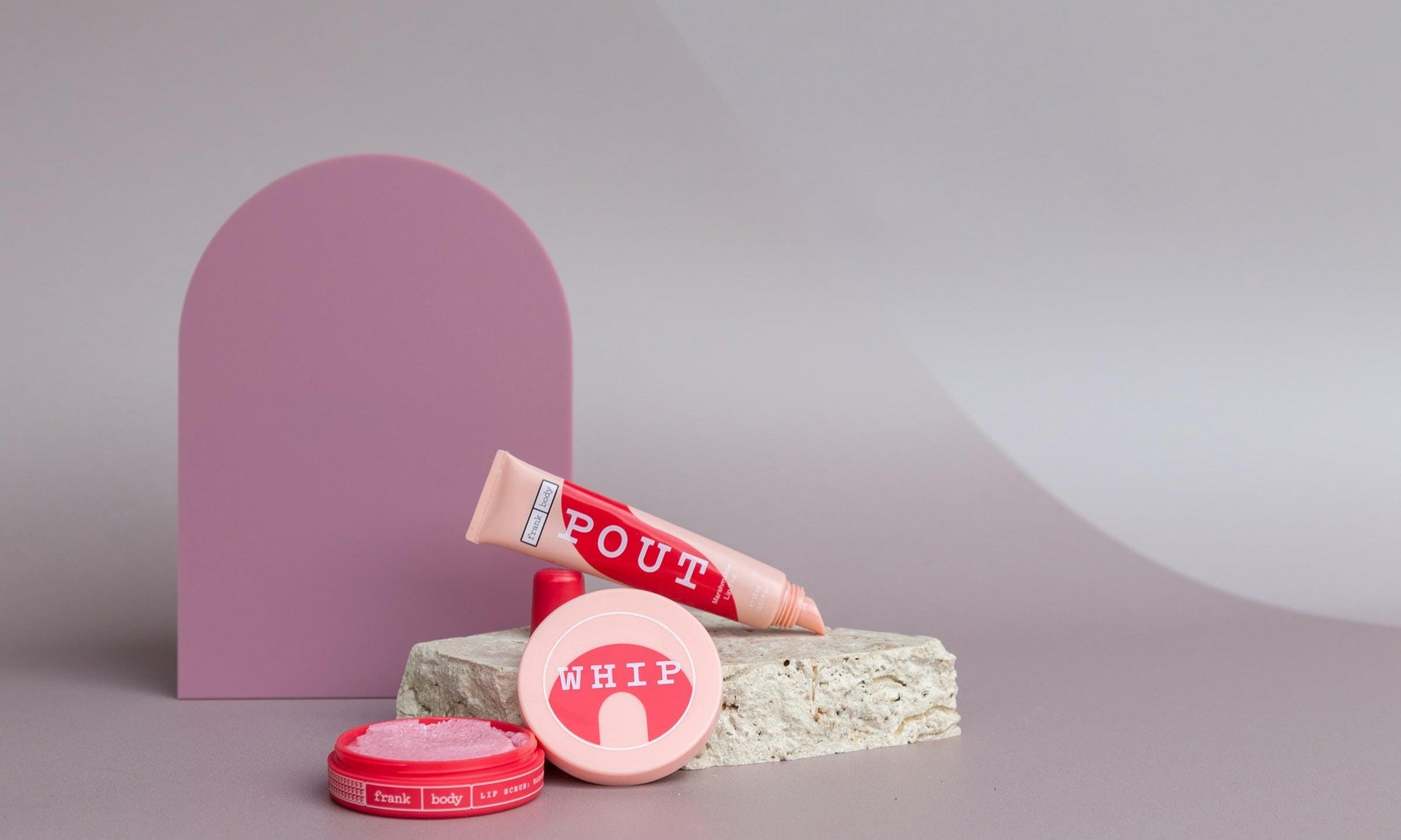 Large acrylic arch and travertine props on taupe vinyl backdrop for product photography - backdrop collective