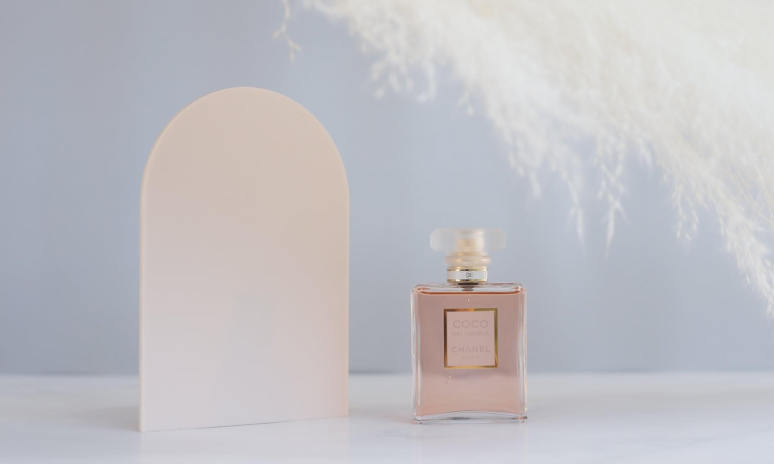 Large acrylic beige arch prop with feather and chanel perfume for product photography - backdrop collective