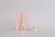 Large acrylic arch prop with diamond ring and timber ring stand on beige vinyl backdrop - backdrop collective