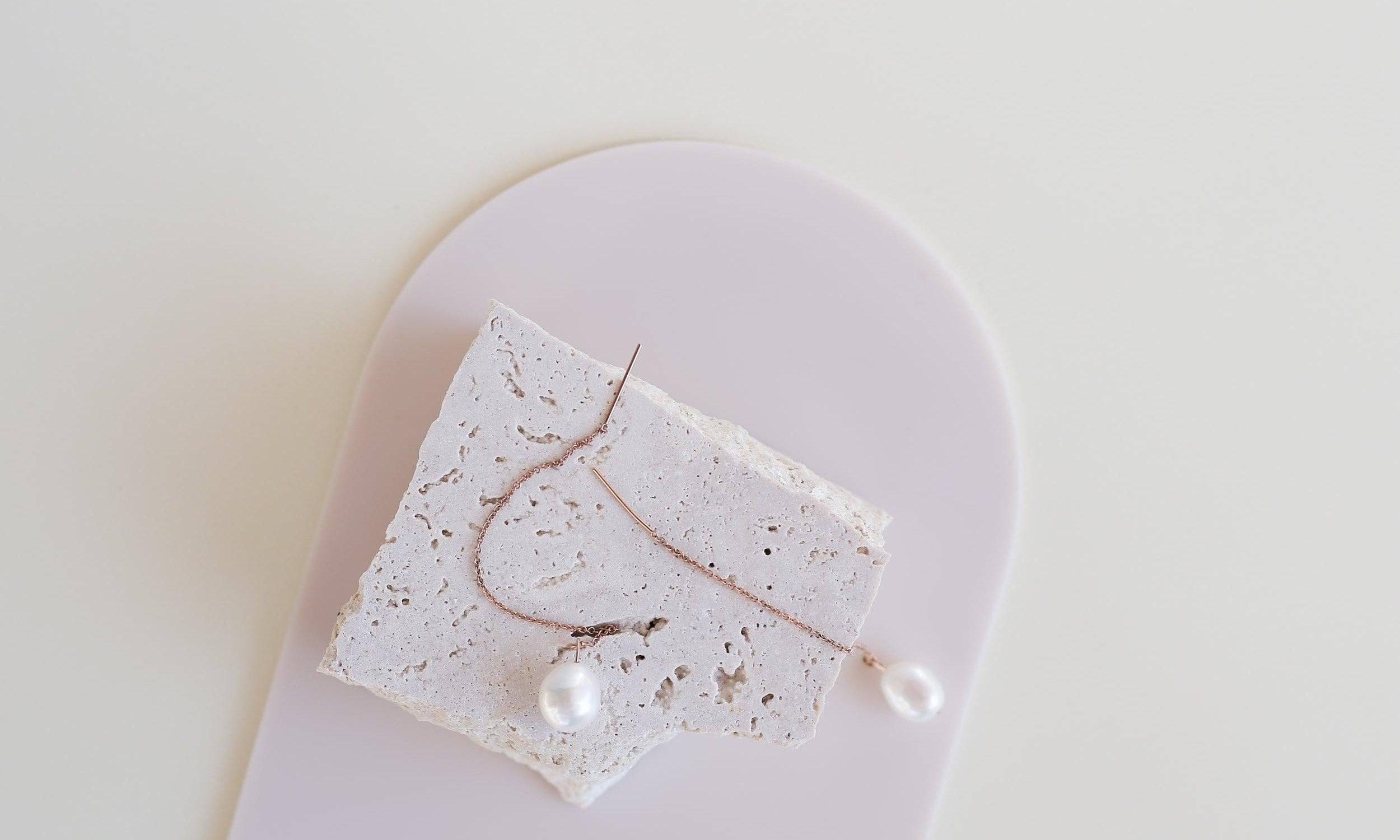 Medium beige buttercream acrylic arch and travertine props photographed pearl drop earrings - backdrop collective australia