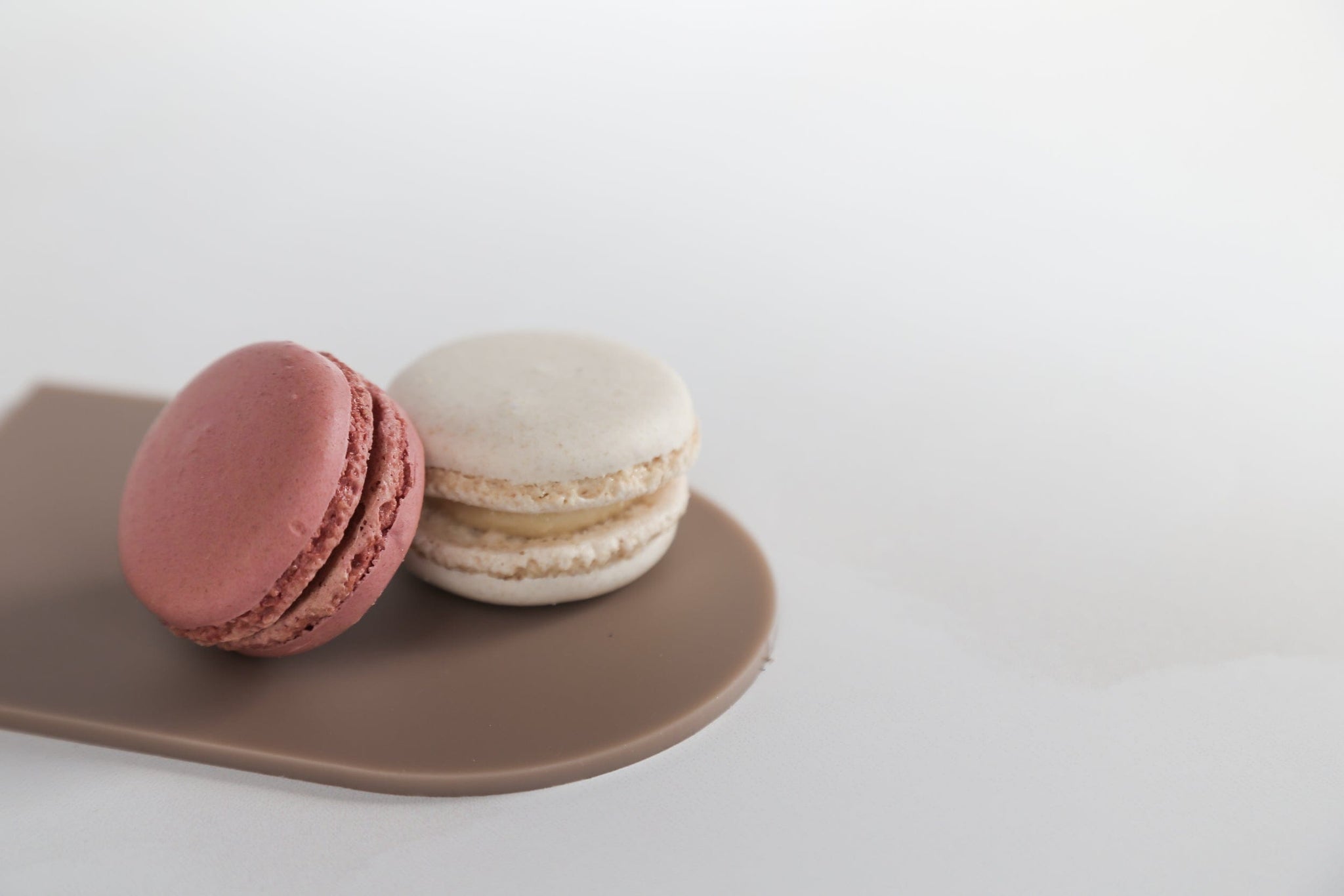 brown acrylic arch photographed with macaroons on a white vinyl photography backdrop - backdrop collective australia