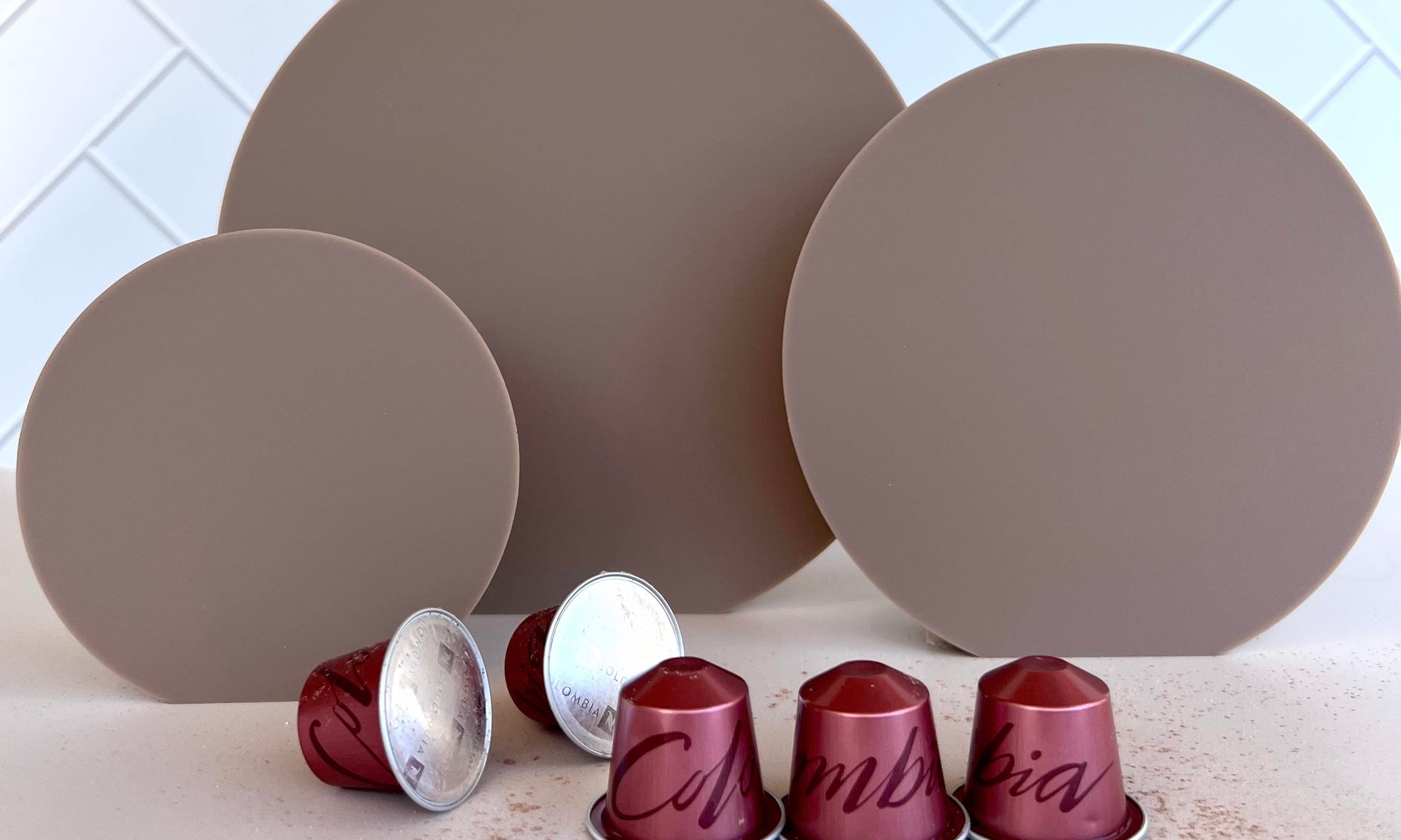 coffee coloured acrylic circle props with herringbone tile backdrop and Nespresso coffee pods - backdrop collective