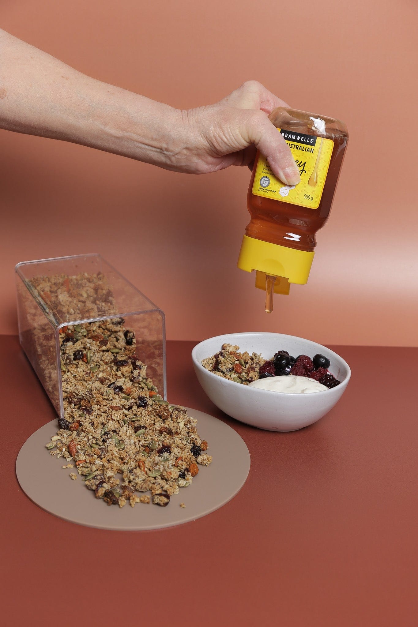 honey drip over granola and yogurt. food photography with rust coloured double sided photography backdrop - backdrop collective australia 