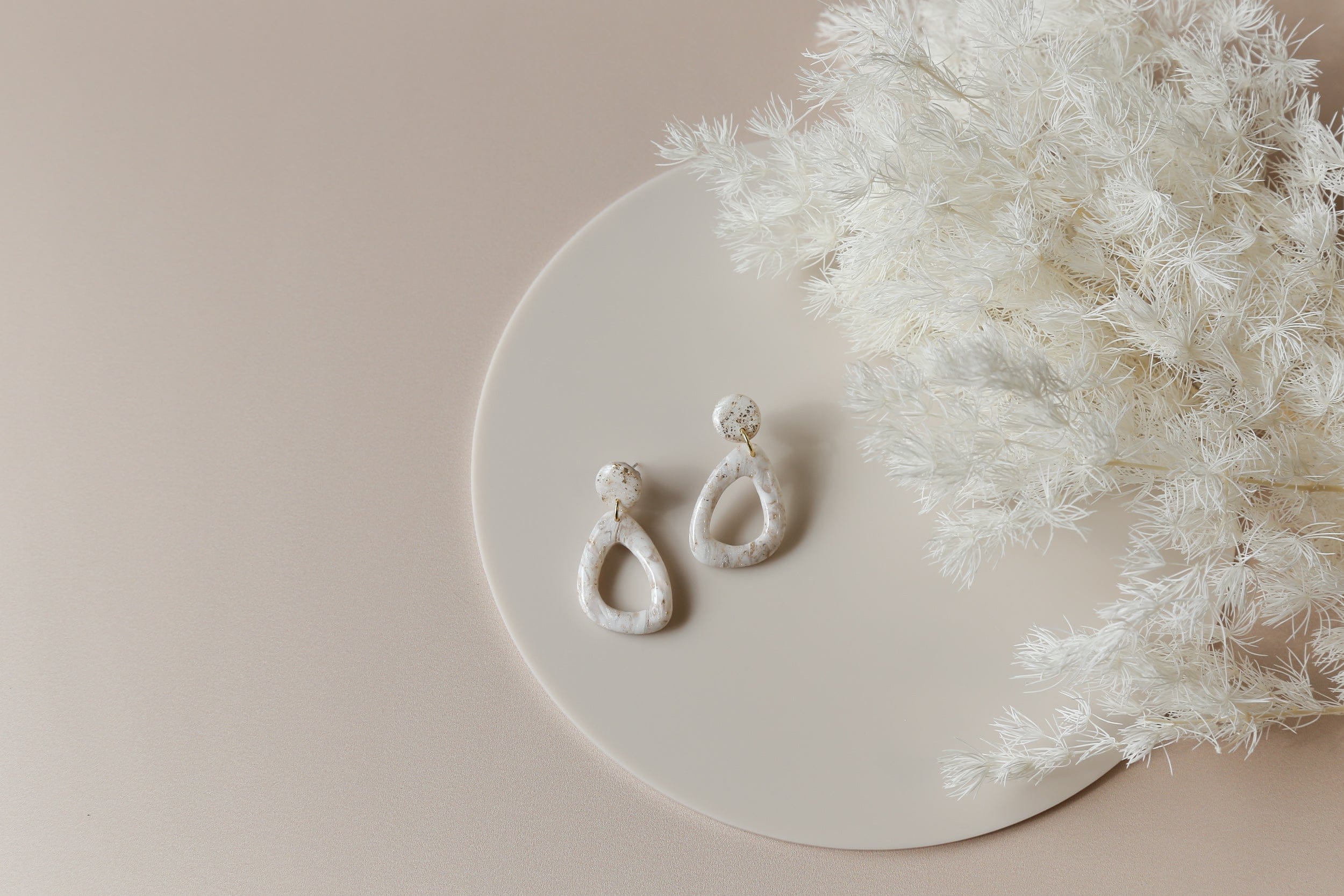 solid colour beige vinyl photography backdrops with acrylic circle props for earrings and jewellery product photography - Backdrop Collective Melbourne