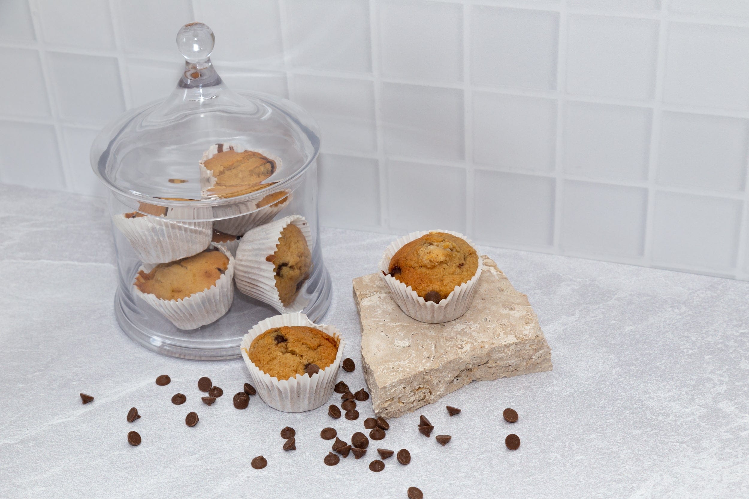 choc chip muffins on travertine props and grey concrete and white tile vinyl photography backdrop - backdrop collective australia