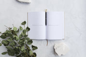 dream diary and diamond pen photographed with gum leaves on a white stone photography backdrop - backdrop collective australia 