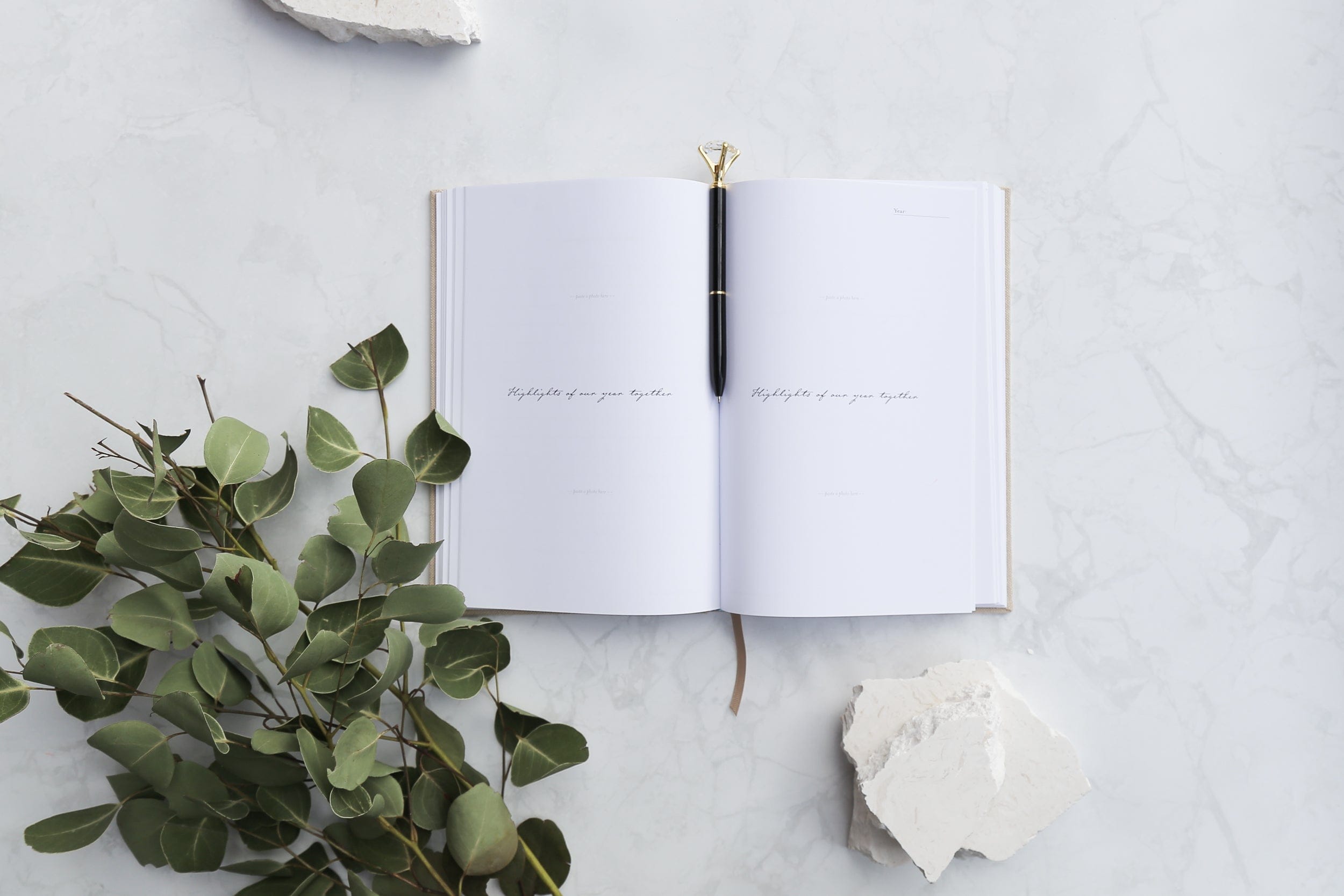dream diary and diamond pen photographed with gum leaves on a white stone photography backdrop - backdrop collective australia 