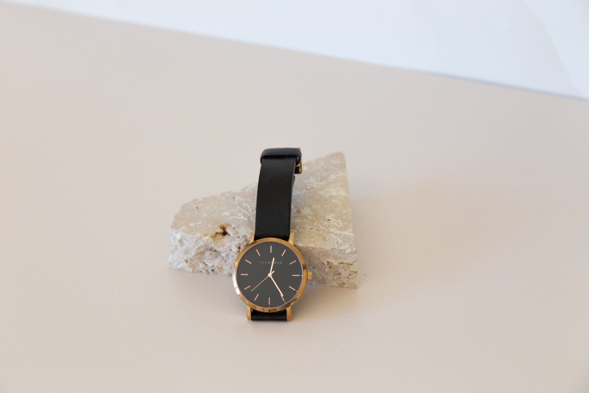 Travertine stone photography prop on beige backdrop with horse watch - backdrop collective melbourne