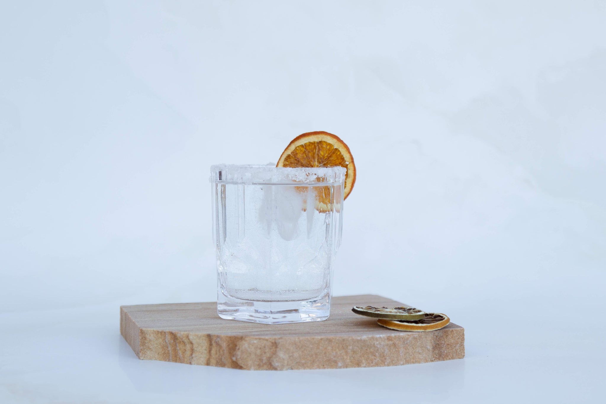 Fresh cocktails with dried citrus on white photography backdrop with Tuscan natural sandstone stone photography prop - backdrop collective Australia