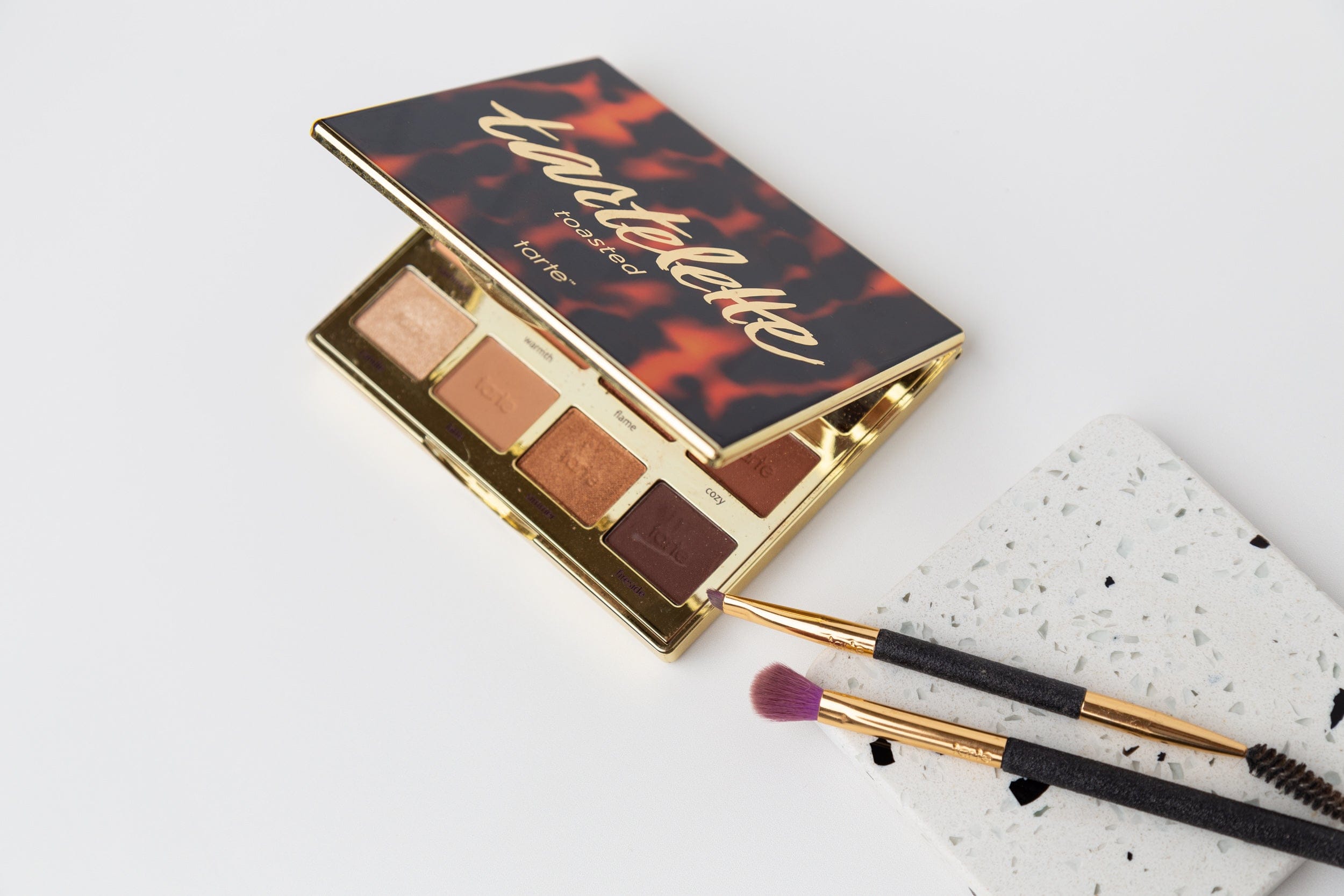 tarte eyeshadow palette and brushes on pure white double-sided vinyl backdrop - backdrop collective