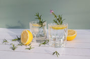 cocktail with lemon and rosemary on white timber vinyl photography backdrop - Backdrop Collective