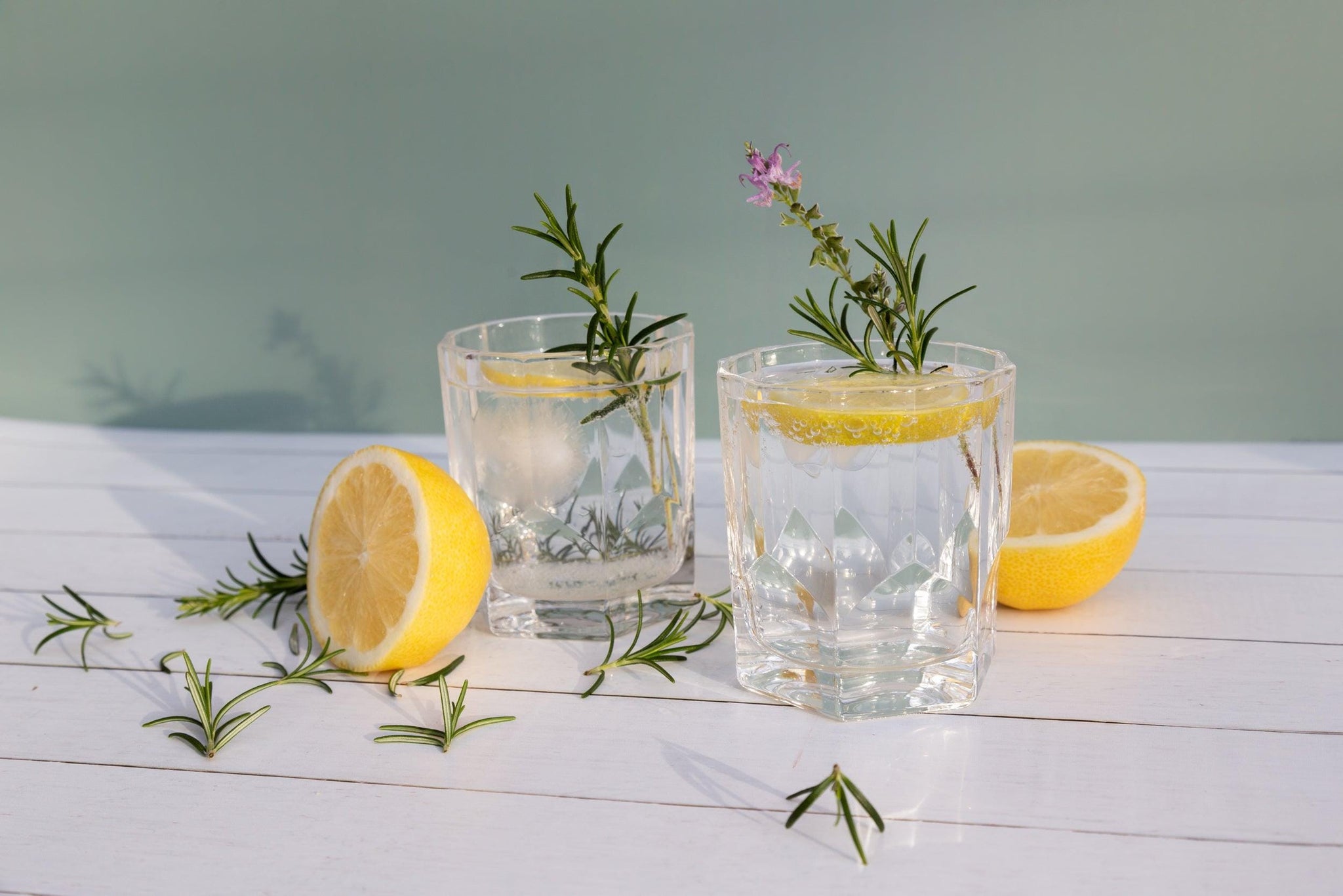 cocktail with lemon and rosemary on white timber vinyl photography backdrop - Backdrop Collective