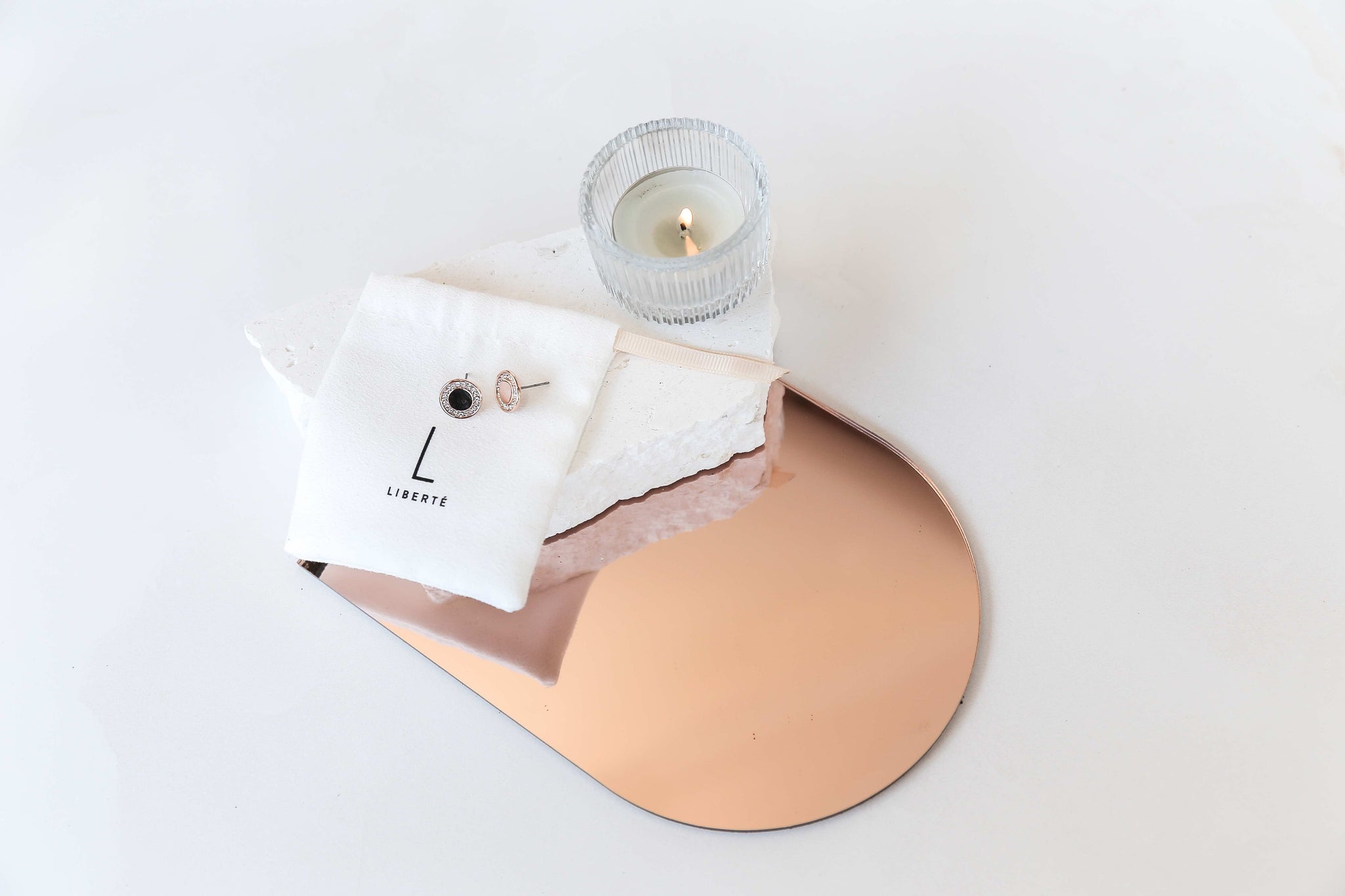 rose gold acrylic mirror and rose gold earrings on white limestone natural stone prop bundle - backdrop collective melbourne australia 